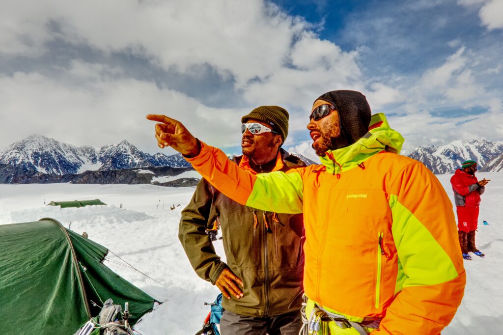 Black mountaineers pointing and looking into the distance